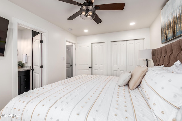 bedroom with ensuite bath, ceiling fan, and multiple closets