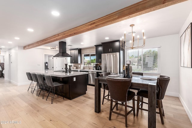 dining area featuring a notable chandelier, a healthy amount of sunlight, beam ceiling, and light hardwood / wood-style flooring