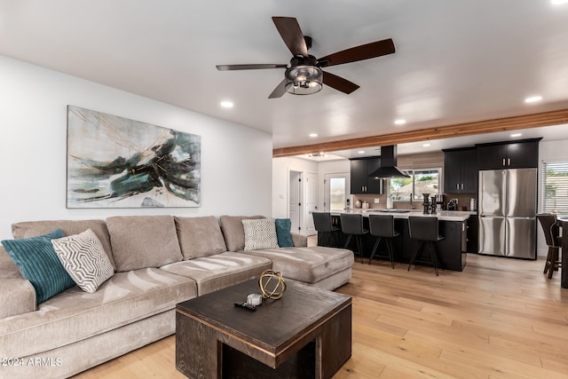 living room with ceiling fan, plenty of natural light, and light hardwood / wood-style floors