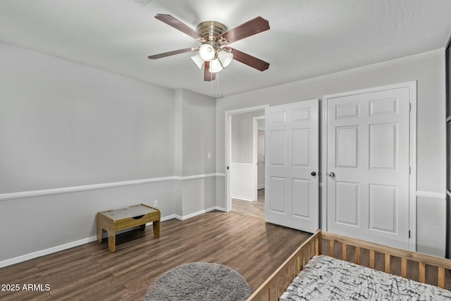 bedroom featuring ceiling fan, baseboards, and wood finished floors