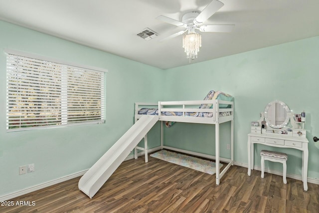 bedroom featuring baseboards, visible vents, ceiling fan, and wood finished floors