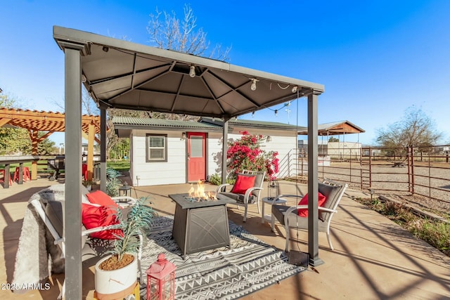 view of patio / terrace featuring an outdoor fire pit, fence, and a pergola