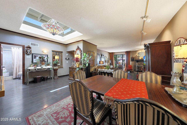 dining area featuring a skylight, dark wood finished floors, and baseboards