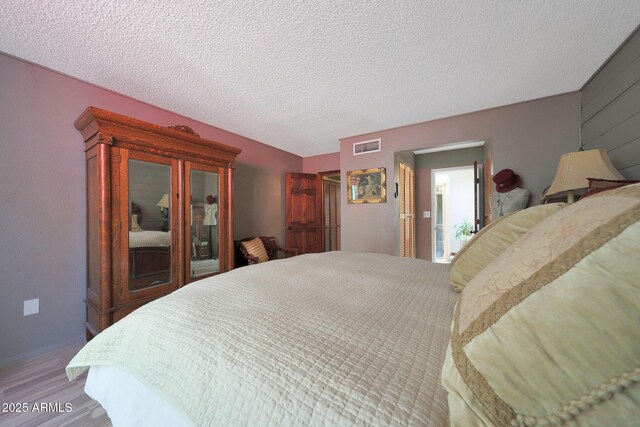 bedroom featuring wood finished floors and a textured ceiling