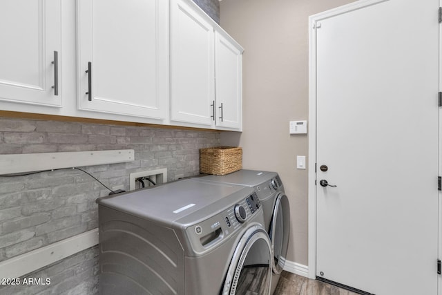 2605 W Desert Marigold Dr, Phoenix, AZ 85085 - laundry room featuring wood finished floors, baseboards, washing machine and clothes dryer, and cabinet space