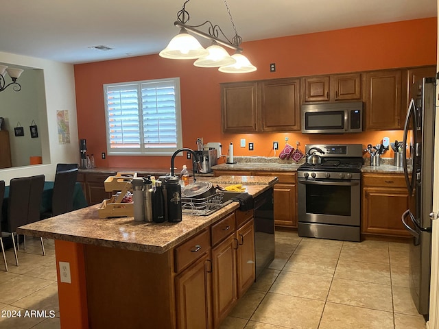 kitchen featuring a center island, appliances with stainless steel finishes, decorative light fixtures, and light tile patterned floors