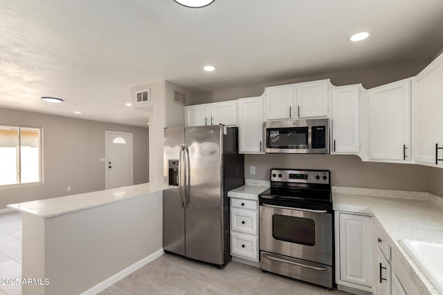 619 E Jensen St Unit 14, Mesa, AZ 85203 - kitchen featuring stainless steel appliances, a peninsula, white cabinetry, recessed lighting, and light stone countertops