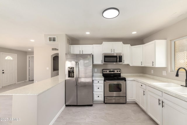 619 E Jensen St Unit 14, Mesa, AZ 85203 - kitchen with appliances with stainless steel finishes, a peninsula, white cabinets, recessed lighting, and light stone counters