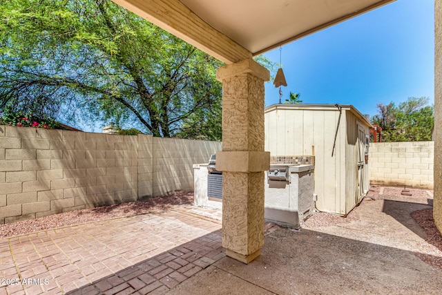 619 E Jensen St Unit 14, Mesa, AZ 85203 - fenced backyard featuring a patio area, an outdoor kitchen, and a storage shed