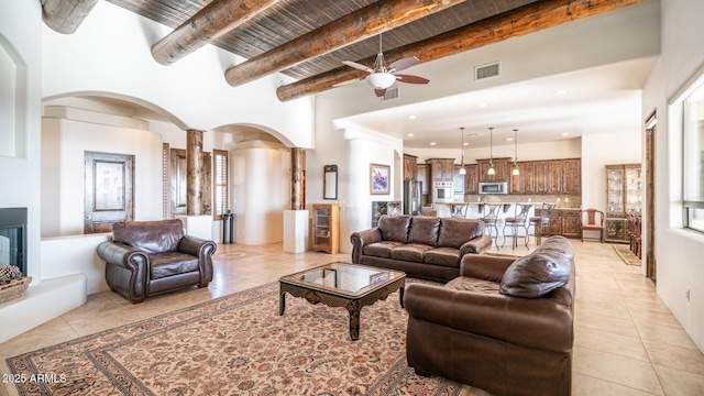 3168 S Yaqui Ln, Gold Canyon, AZ 85118 - tiled living room featuring ceiling fan, decorative columns, beamed ceiling, and a high ceiling