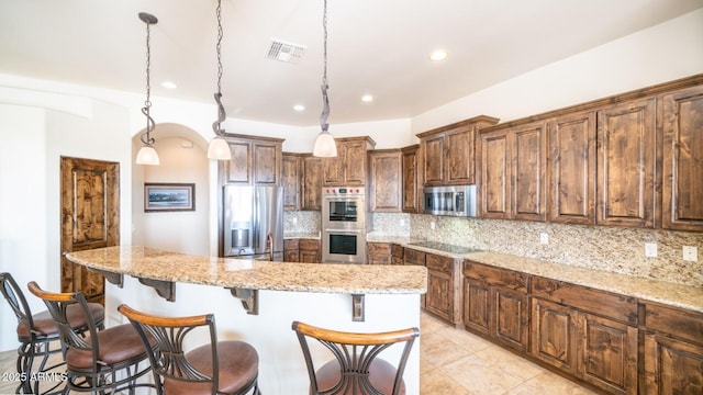 3168 S Yaqui Ln, Gold Canyon, AZ 85118 - kitchen featuring a kitchen island, appliances with stainless steel finishes, decorative light fixtures, backsplash, and light stone countertops