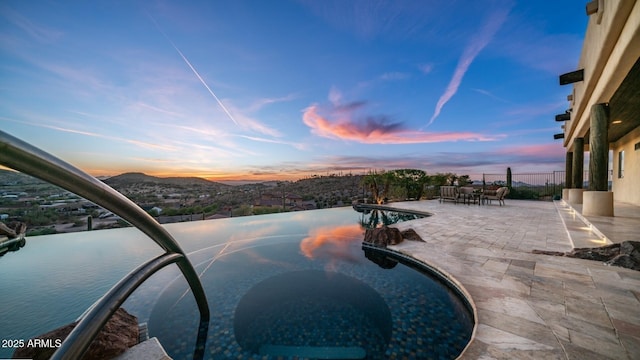 3168 S Yaqui Ln, Gold Canyon, AZ 85118 - pool at dusk with a mountain view and a patio area