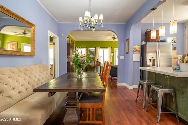 39 E Hoover Ave, Phoenix, AZ 85004 - dining area with arched walkways, baseboards, dark wood finished floors, and ceiling fan with notable chandelier