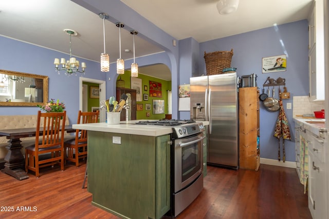 39 E Hoover Ave, Phoenix, AZ 85004 - kitchen with arched walkways, stainless steel appliances, tasteful backsplash, dark wood-style floors, and green cabinets