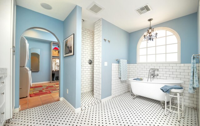 39 E Hoover Ave, Phoenix, AZ 85004 - full bath featuring visible vents, an inviting chandelier, a tile shower, and a soaking tub