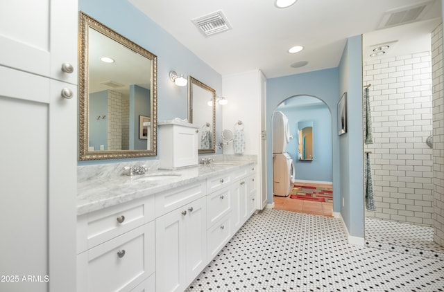 39 E Hoover Ave, Phoenix, AZ 85004 - full bath with visible vents, a sink, washer / dryer, and a tile shower