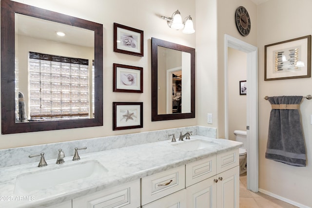 1819 W Deer Creek Rd, Phoenix, AZ 85045 - bathroom featuring toilet, double vanity, tile patterned floors, and baseboards