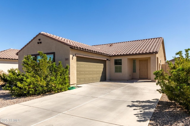 mediterranean / spanish-style house featuring a tiled roof, an attached garage, driveway, and stucco siding