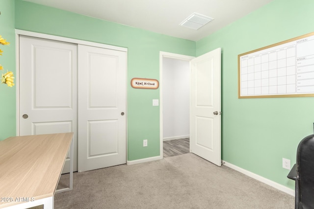 unfurnished office with baseboards, visible vents, and light colored carpet