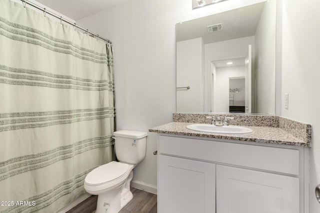 full bath with visible vents, toilet, wood finished floors, and vanity