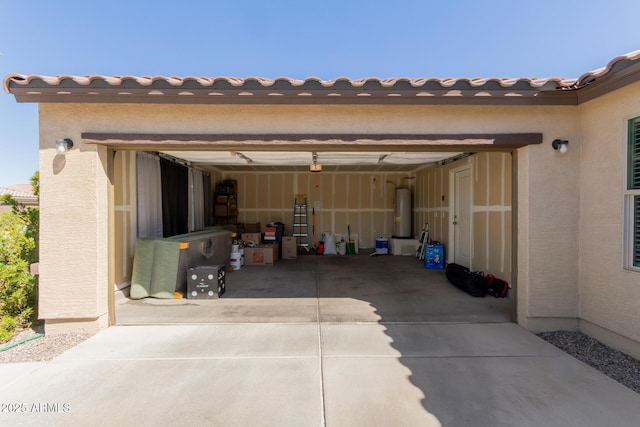 garage with concrete driveway and gas water heater