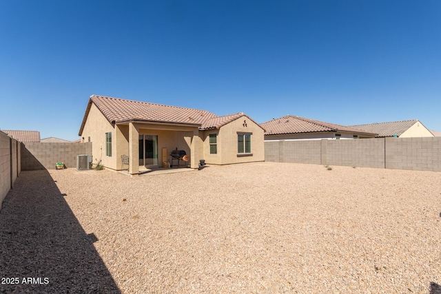 back of property with cooling unit, a fenced backyard, a tile roof, stucco siding, and a patio area