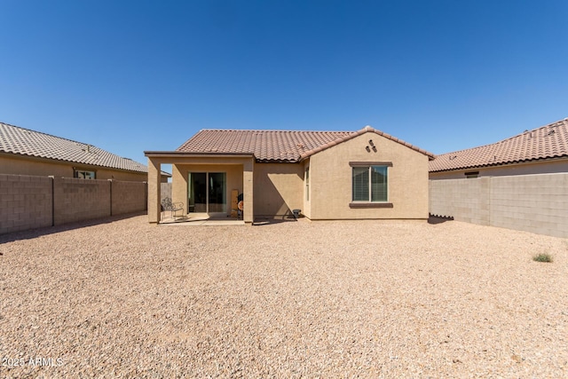 rear view of house with a patio area, a fenced backyard, a tiled roof, and stucco siding