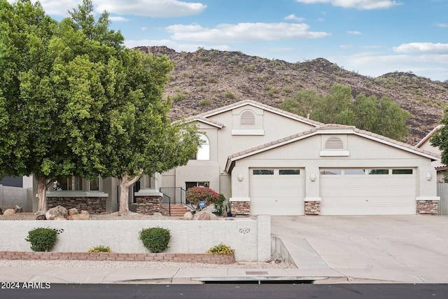 view of front property with a mountain view and a garage