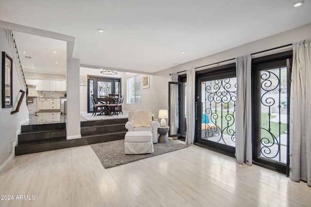 foyer entrance with light hardwood / wood-style flooring and a notable chandelier