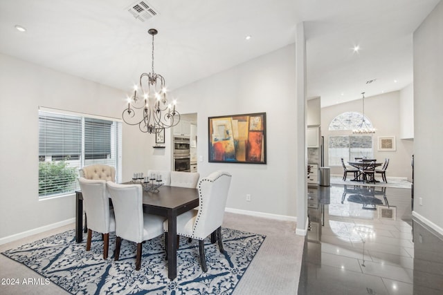 dining space featuring a healthy amount of sunlight, lofted ceiling, and a chandelier