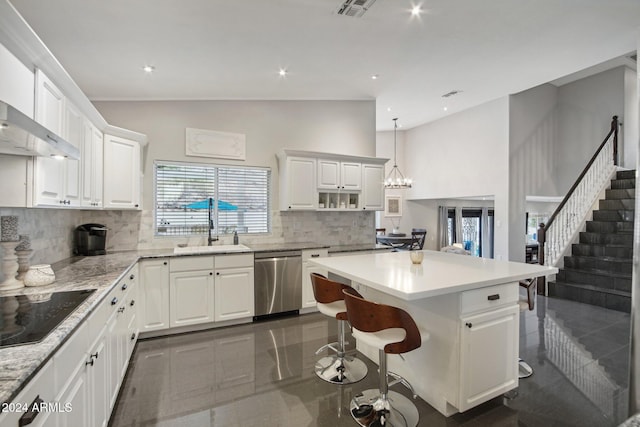 kitchen with dishwasher, pendant lighting, vaulted ceiling, decorative backsplash, and white cabinets