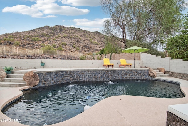 view of pool with pool water feature and a mountain view