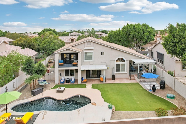 rear view of property with a patio, a balcony, a fenced in pool, and a lawn