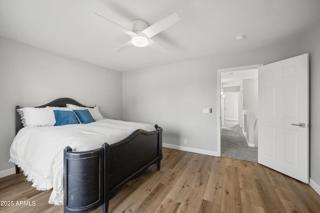 bedroom featuring a ceiling fan, baseboards, and wood finished floors