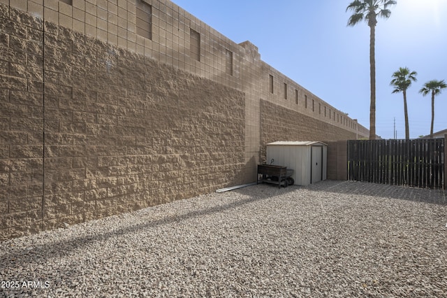 exterior space with a storage unit and fence