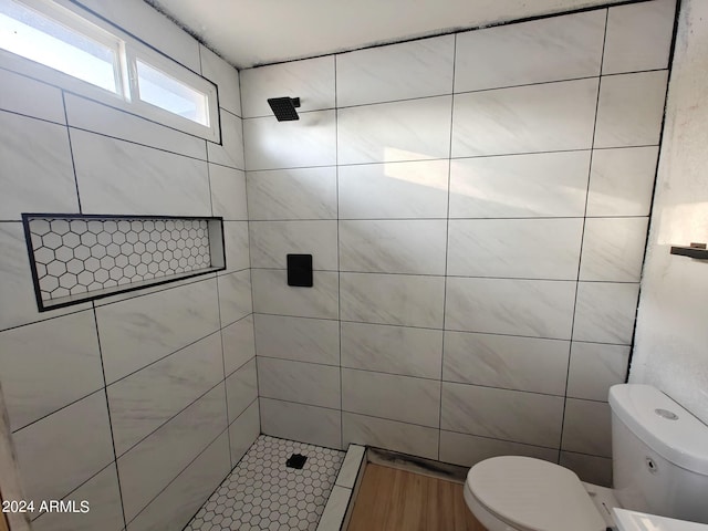 bathroom with tiled shower and toilet