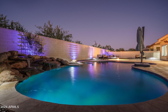 pool at dusk featuring a patio area