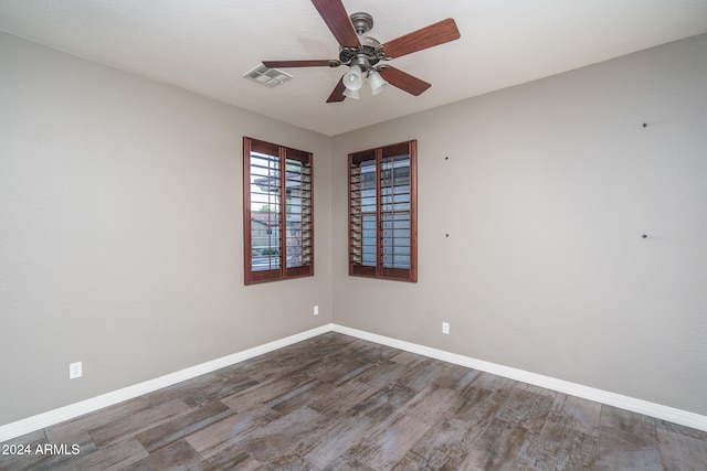 spare room with dark wood-type flooring and ceiling fan