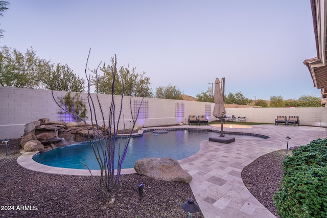 view of swimming pool with pool water feature and a patio area