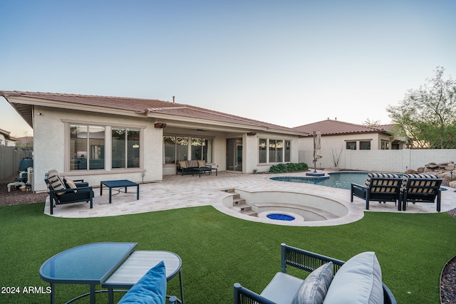 rear view of house with a yard, a pool with hot tub, an outdoor hangout area, and a patio area