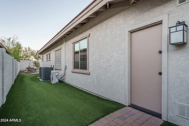 exterior space featuring central AC unit and a yard