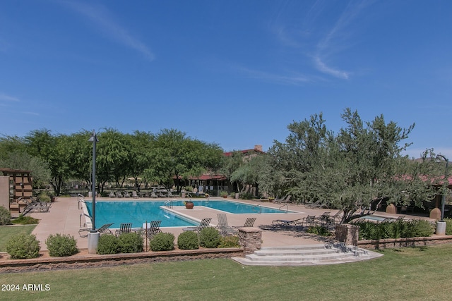 view of swimming pool featuring a patio and a yard