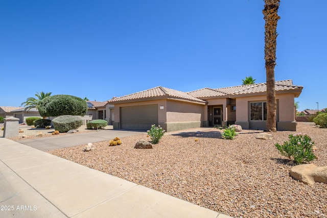 16354 W Labyrinth Ln, Surprise, AZ 85374 - mediterranean / spanish-style house with stucco siding, a tile roof, an attached garage, and driveway