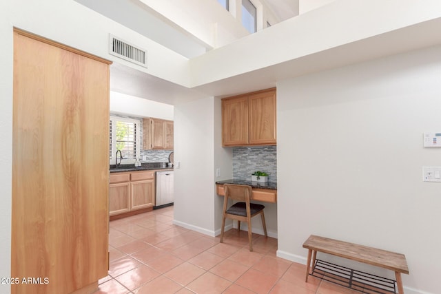 kitchen featuring dishwasher, sink, built in desk, and light tile patterned floors