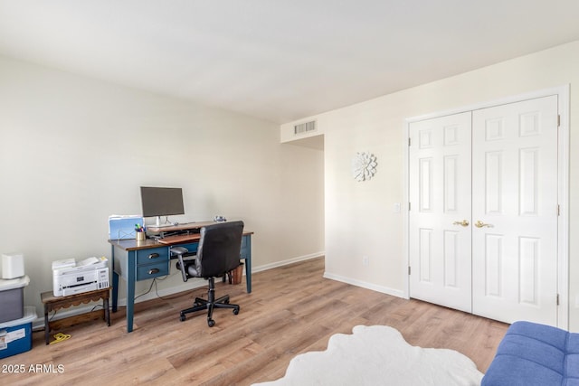 home office with light hardwood / wood-style floors