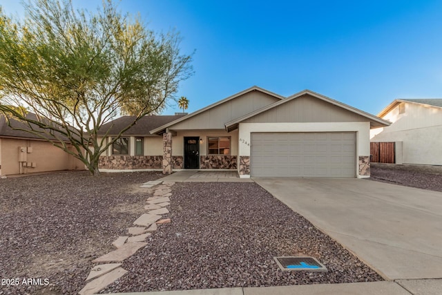 ranch-style house featuring a garage, concrete driveway, and stone siding