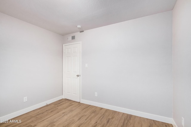 unfurnished room with baseboards and light wood-type flooring