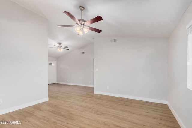 empty room with vaulted ceiling, a ceiling fan, light wood-style floors, and baseboards
