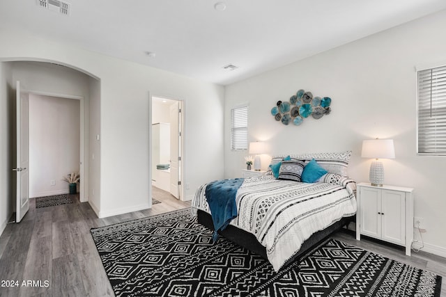 bedroom featuring hardwood / wood-style flooring and connected bathroom