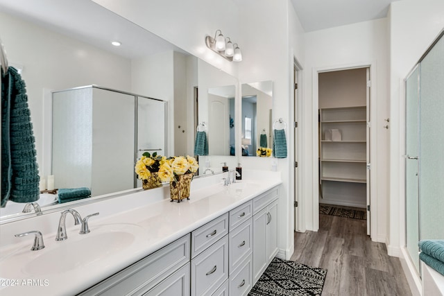 bathroom featuring a shower with shower door, vanity, and hardwood / wood-style flooring